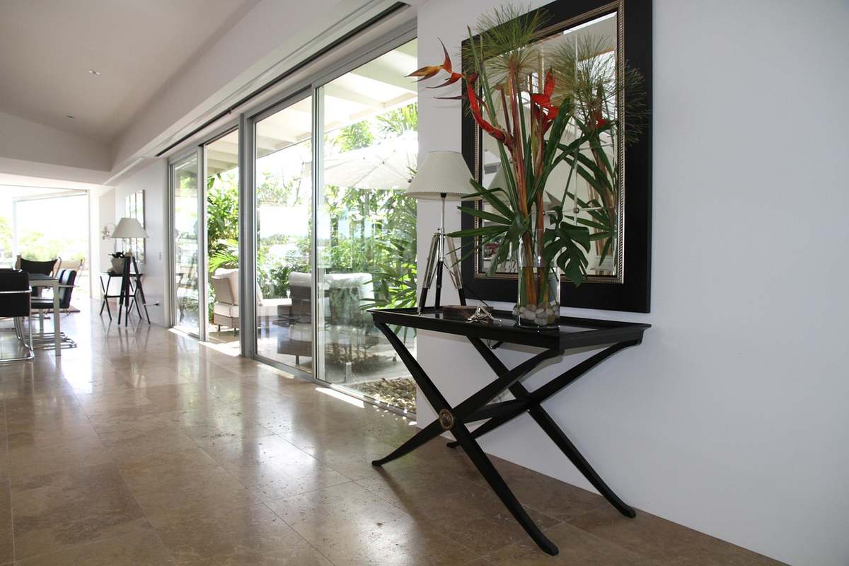 Entrée d'une maison ouverte sur le salon, avec large baie vitrée et console décorée